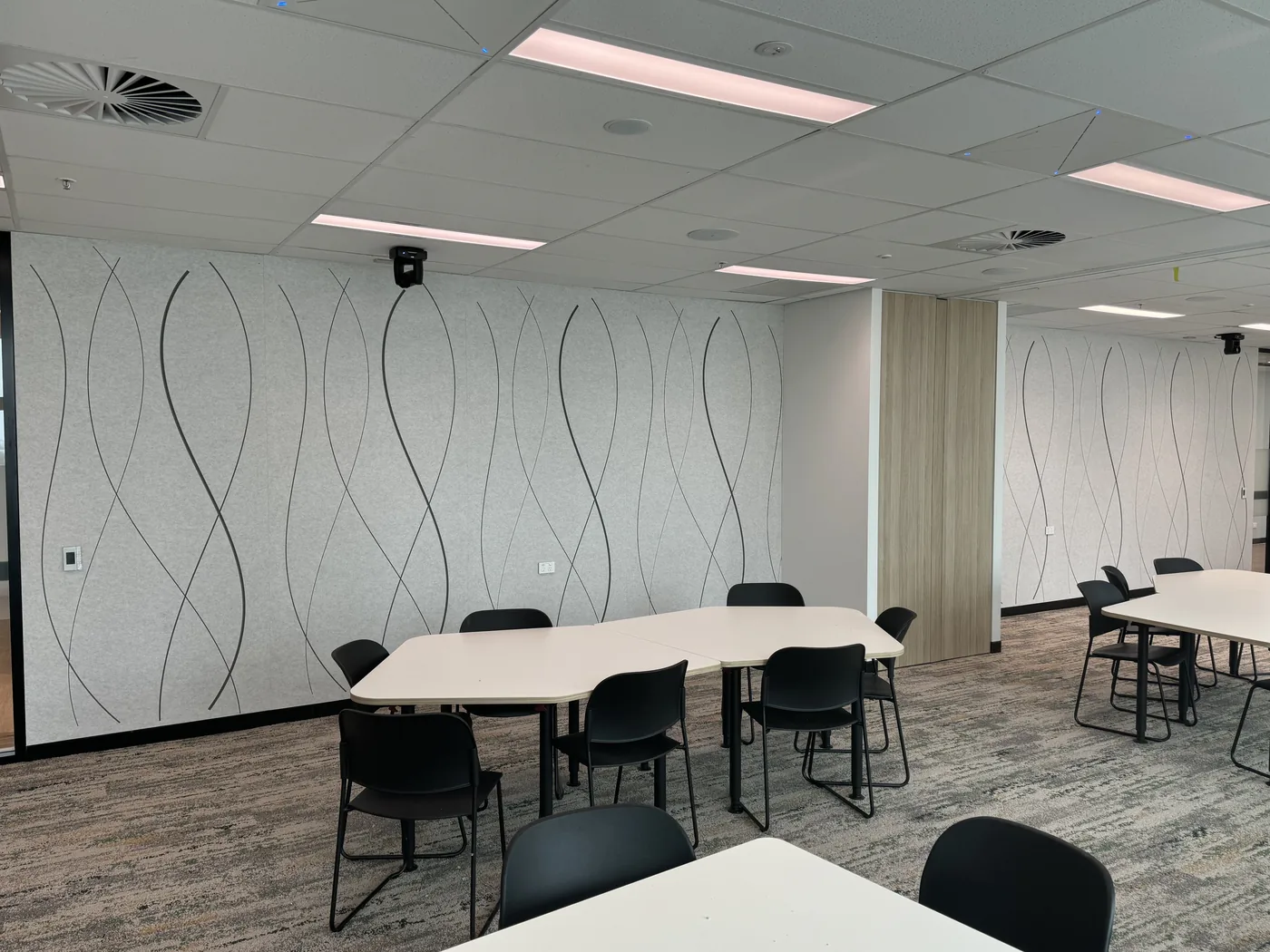 Wide collaboration space with wavy-pattern acoustic wall panels