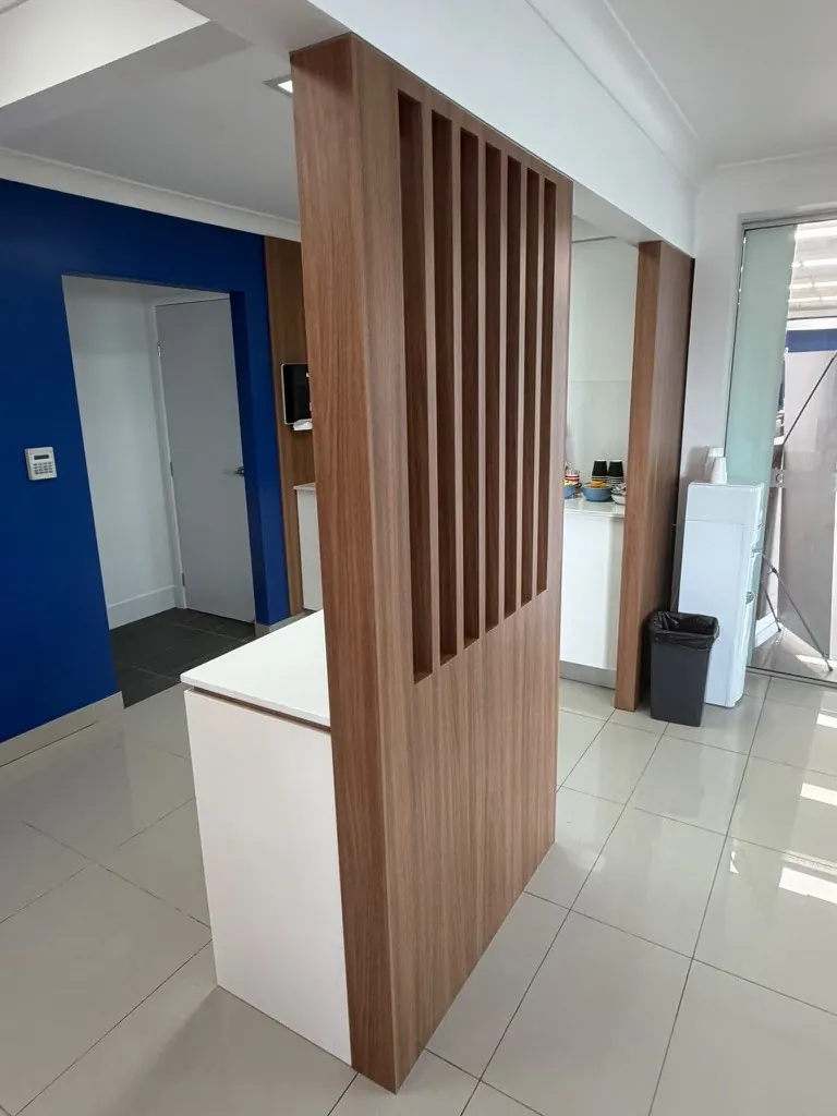 Walnut slatted screen joinery viewed from the reverse side in a Springwood dealership showroom