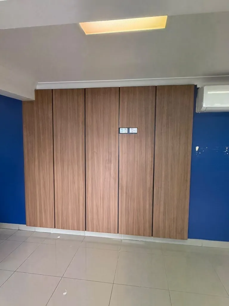 Full-height custom walnut wall cabinetry against a blue feature wall, commercial joinery by HPCI
